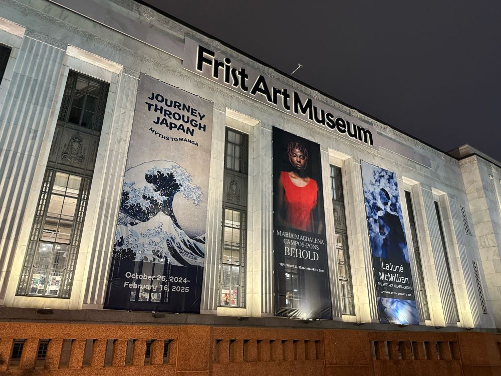 Image of the outside of a white stone building that reads Frist Art Museum with three large banners advertising art exhibitions on the side of the building.
