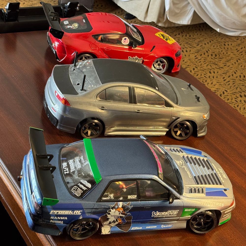 Three rc cars on a desk in a hotel room