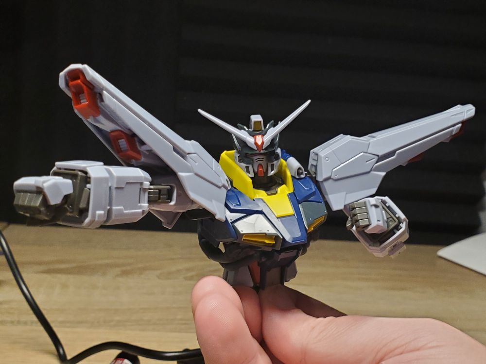 MG Providence Gundam posed as striking out with its lead hand, being held up at the waist as only the torso, arms, shoulders, and head are complete.