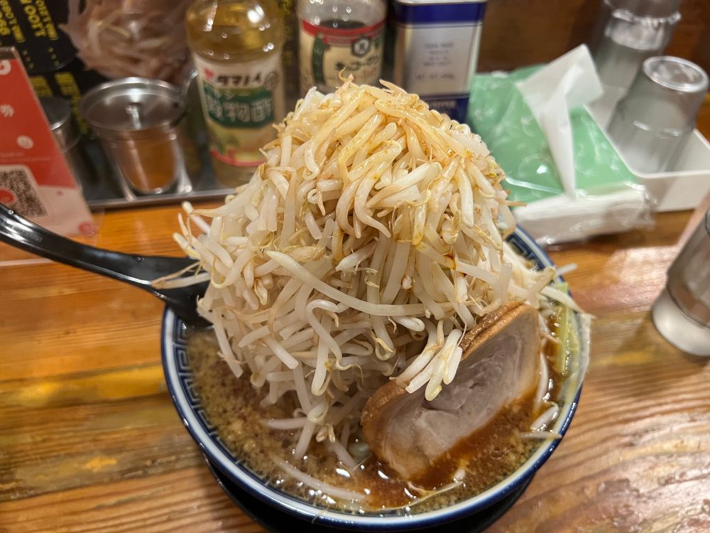 以前行った郡山の有名店(くさび)。こちらは本店となります。写真は二郎系の三郎。約1150円となかなかの値段です。学割があるとのことで、日大や奥羽大の学生さんだと行った方もいるのかな？
地元に本拠地を置くバスケB2福島の応援しているお店みたいでした。
(ホームアリーナは駅から歩いて30分ほど。野球などが開催される開成山公園近くにあります)
調整可能なのは野菜(もやし)・カラメ・ニンニク・アブラの４種類。カラメはマシマシだと先日紹介いたしました末廣くらいのしょっぱさにできます。
写真例は野菜マシマシ、カラメマシマシ、ニンニクマシ。