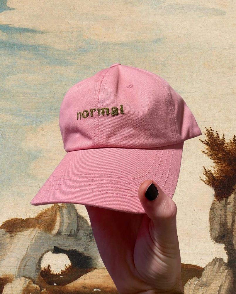 pinke cap mit frakturschrift „normal“ in olivgrün