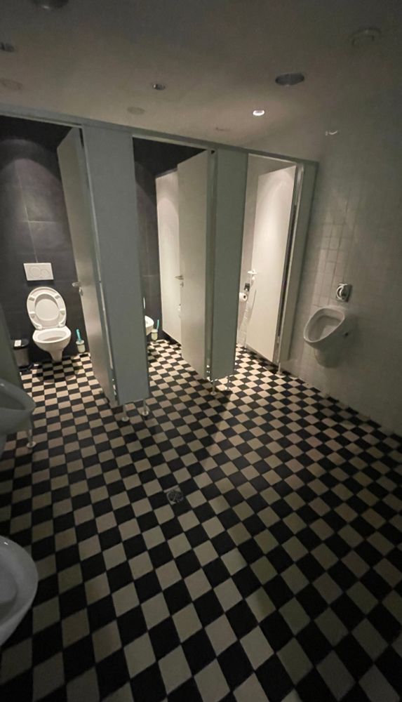 toilette mit schachbrettkacheln und creepy beleuchtung