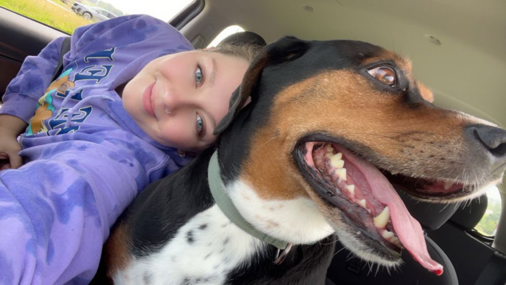 car selfie of hailien and morty. she’s leaning so far across the car to quickly snag a selfie before morty notices and pulls away because he hates pictures 