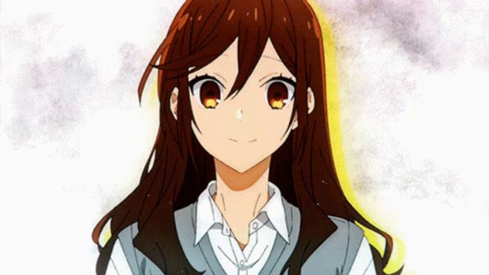 a girl with long brown hair is wearing a white shirt and a grey vest .