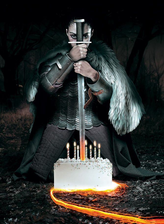 The Ironsworn cover image, which shows a kneeling warrior grasping a sword that flames red-hot at its tip. The image is modified to show the warrior stabbing the sword into a birthday cake with 7 candles.