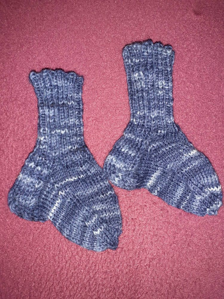 Selbstgestrickte Babysöckchen in verschiedenen Blautönen 