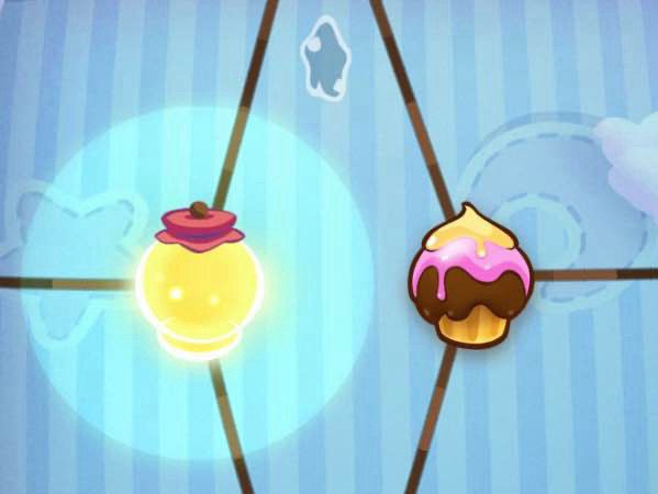 A screenshot from Cut the Rope, depicting the candy (being a cupcake) and the lantern (the pillow box's gimmick) suspended by 3 ropes each, in close proximity to each other.