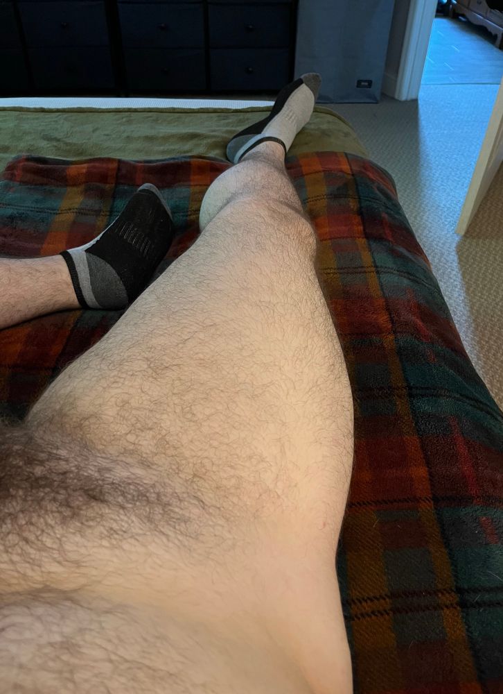Non-explicit but not SFW pic of my right hip and leg, wearing on a pair of socks, laying on my bed, giving a decent look at my pubic hair 
