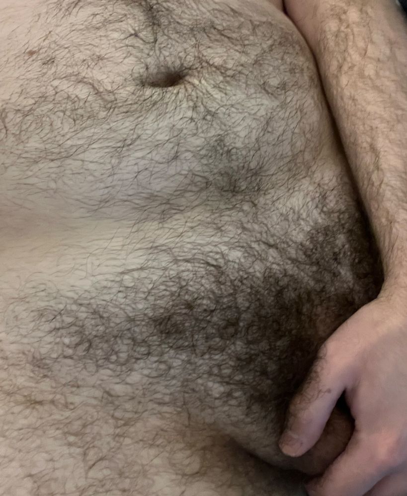 Medium close-up showing my bare lower abdomen and my full pubic area (my “goods”, however, are obscured by my hand)