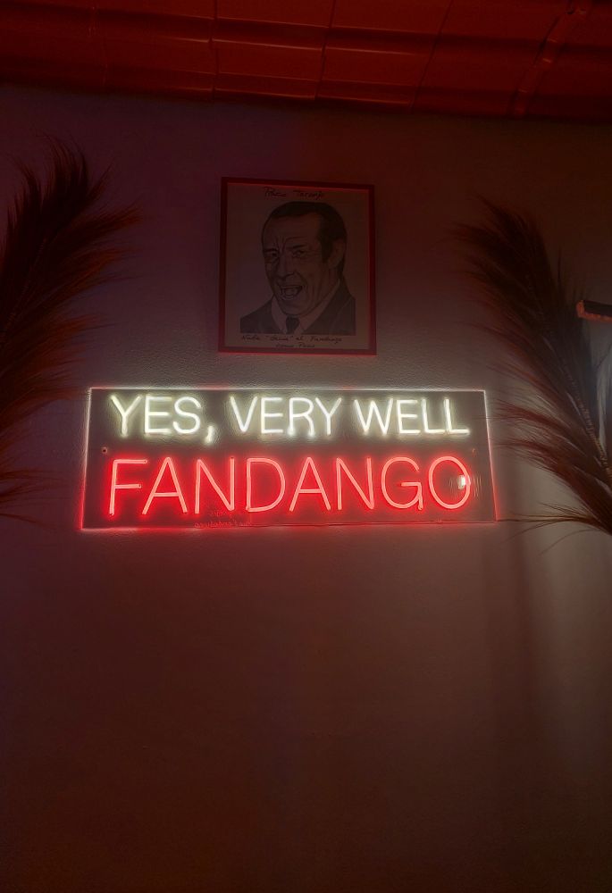 Cartel luminoso donde pone "yes, very well fandango". Encima un retrato de Paco toronjo donde pone "nadie 'decía' el fandango como Paco".