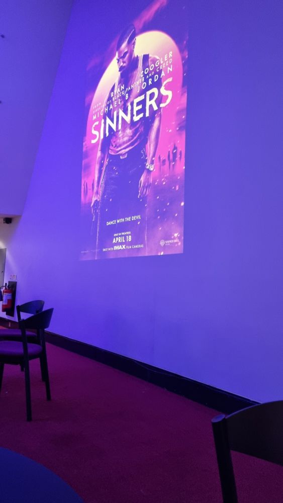 picture of a projection of Sinners (2025) movie poster onto a purple wall