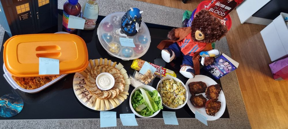 Picture of food spread. Each dish is labelled with name and Doctor Who episode inspired by.
