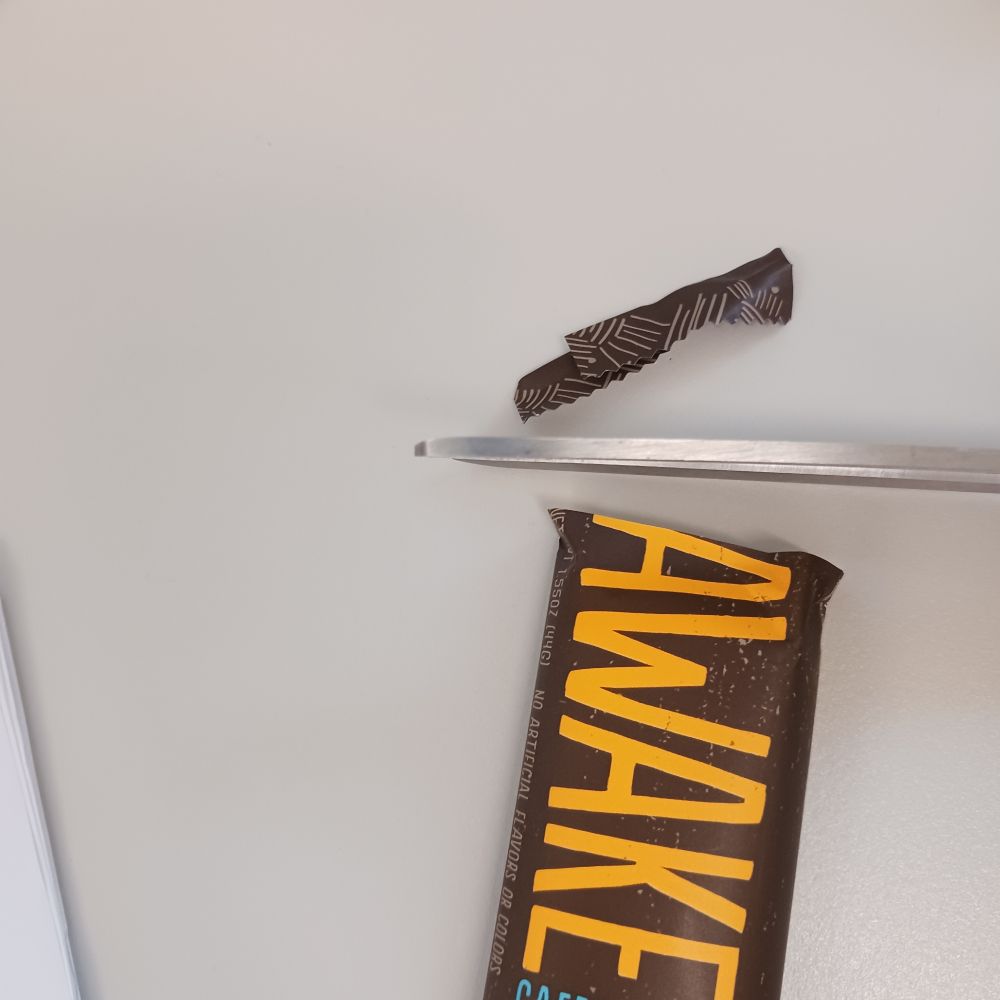 Package snipped with scissors, showing the bar, scissors, and shred of end of package.