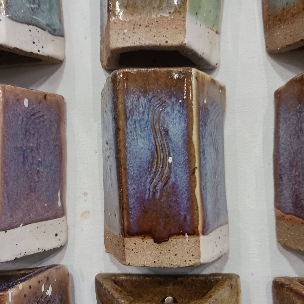 Brown shiny glaze tile with iridescent blue streaks.