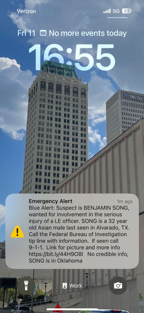 My iPhone Lock Screen showing an Emergency Alert, about someone who injured a police officer in Texas.  It says at the end: "no credible info Song [the suspect] is in Oklahoma".