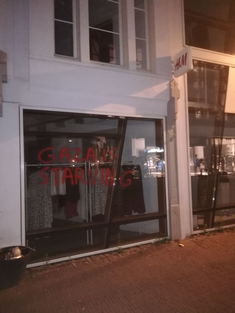 H&M aan de Kleiweg in Gouda, met op de winkelruit in rode graffiti de tekst "Gaza is starving".

H&M sloot in oktober 2023 tijdelijk alle vestigingen in Israël, maar heeft kort daarna besloten om toch zaken te blijven doen in en met een genocidale apartheidstaat.

H&M is ook één van de grootste vervuilers in de fastfashionindustrie, en naar schatting de grootste leugenaar.