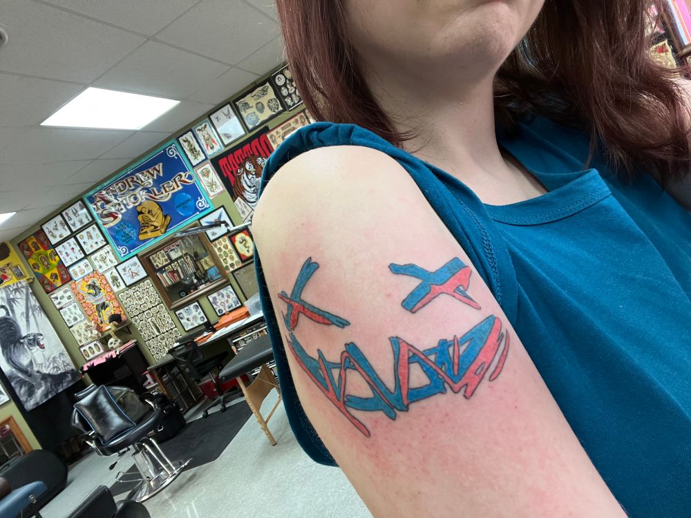 graffiti-style scratchy smiley face tattoo on my bicep, courtesy of jinx league of arcane