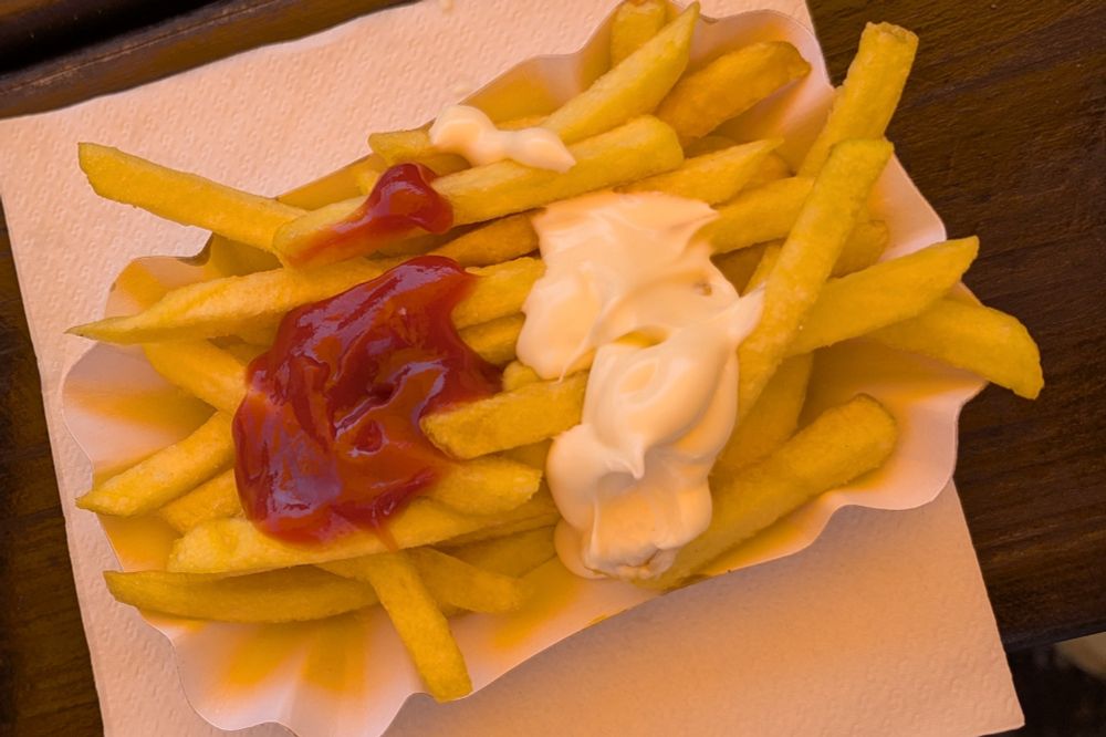Kleine, halbvolle Pommes mit kleinem Klecks Mayo und Ketchup 