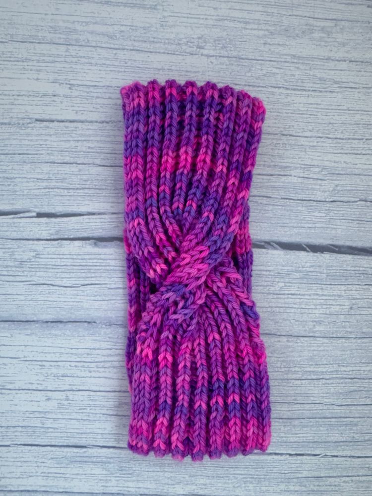 A pink and purple knit headband with a twist made in DK weight yarn by Magiclandyarn. 