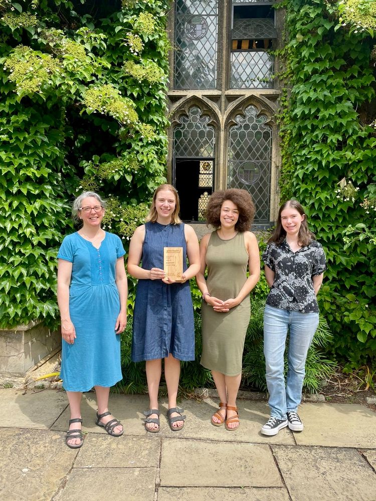 Lincoln College’s Green Impact Team members standing in front of an ivy-covered window, holding the 2024–25 Beyond Gold Green Impact Award.