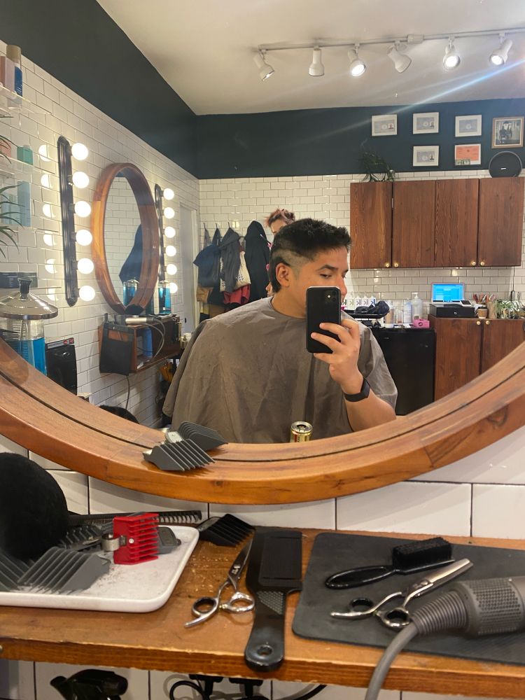 mirror selfie on a barber chair, barber trimmed a line down the side and left everything else untouched