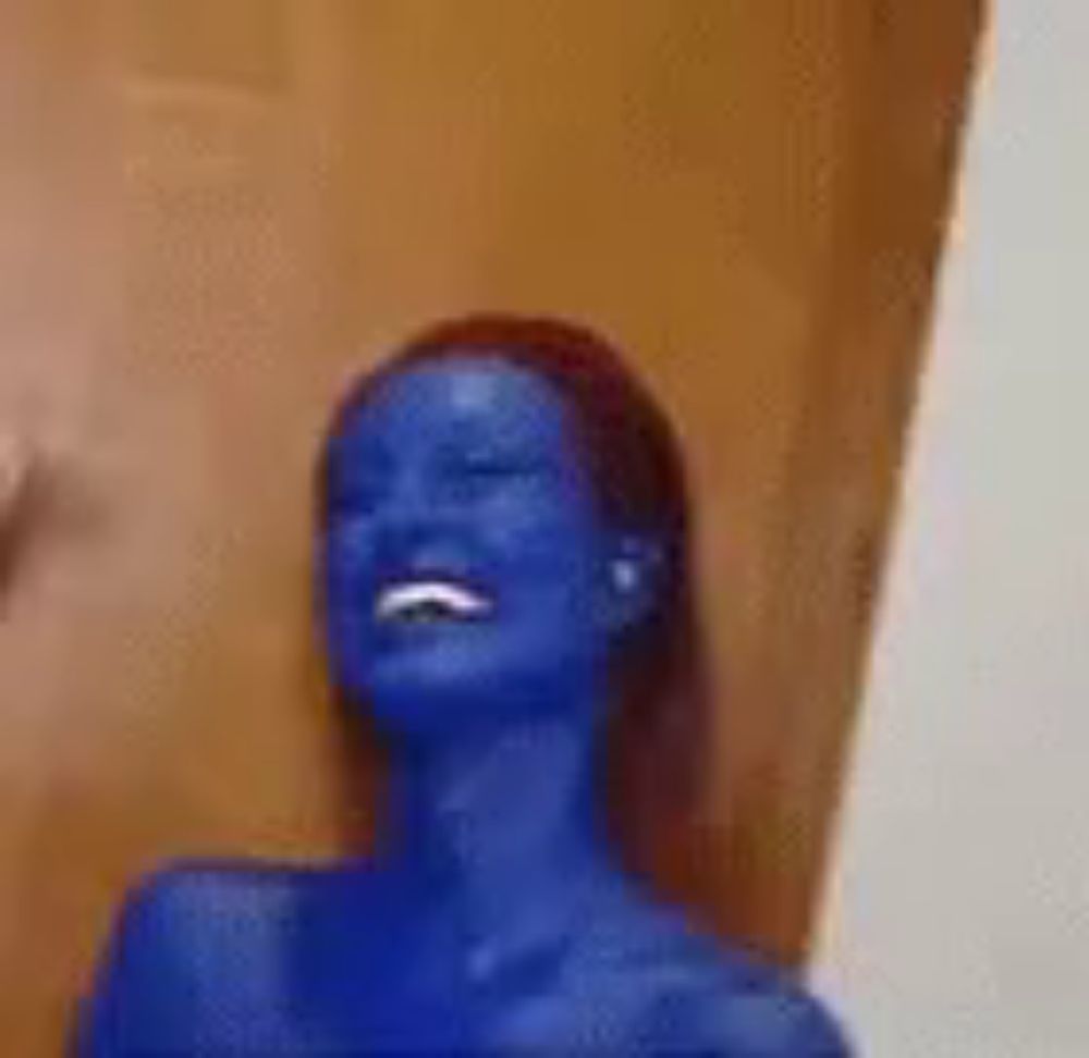 a woman with blue paint on her face is smiling and laughing .