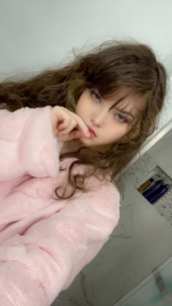 foolish olivia in the bathroom wearing a giant pink fluffy bathrobe