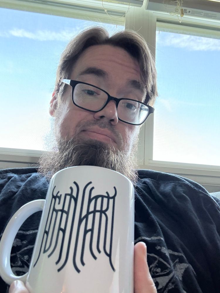 Tony with a coffee mug displaying the Ashenheart logo 