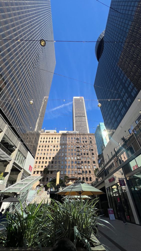 Northeast view of the Aon Center in downtown Los Angeles, as seen from The BLOC. The iconic skyscraper stands tall, surrounded by other buildings that add depth to the cityscape.
