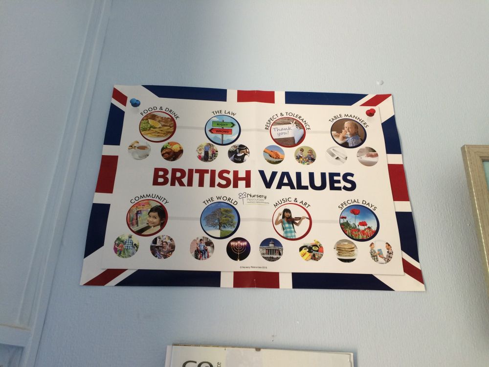 A wall poster of British values seen in a nursery which labels, among other things, British food as tea, fish and chips, and roast beef. Another British value listed is 'table manners' 
