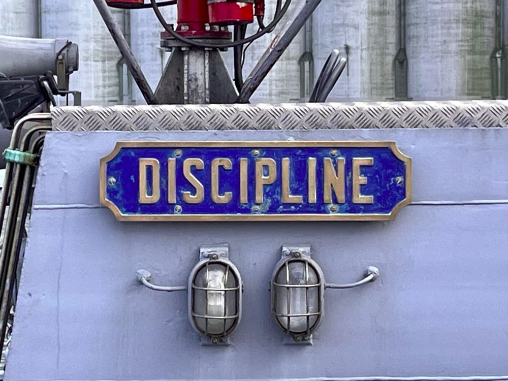panneau "discipline" en lettres argentées sur fond bleu, sur le pont d'un navire de la Marine Nationale, lors de l'Armada de Rouen en 2023. 