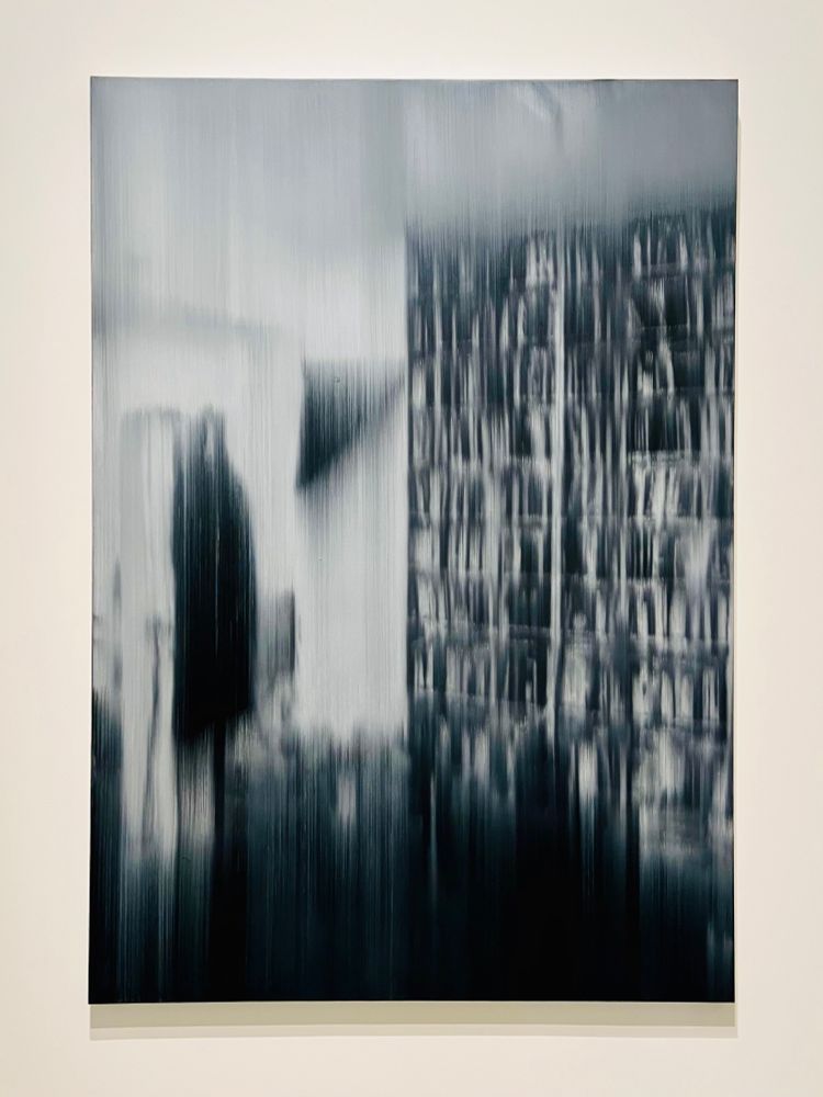 a black and white painting that semi-abstracts a person walking by a bookcase 