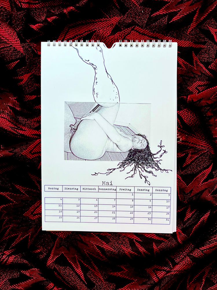 Ein Foto vom Kalender auf rotem Hintergrund. Zu sehen ist das Maiblatt mit dem Tageskalender und einer schwarzen Zeichnung auf weißem Grund. Die Zeichnung wurde über ein Foto gelegt und verlängert das Foto bis an den Kalenderrand heran. Auf dem Foto liegt eine nackte Person auf dem Rücken und hat die Augen geschlossen. Die Person penetriert sich mit einem Gehstock. Die Haare der Person ufern wie Pflanzen aus dem Foto heraus.
