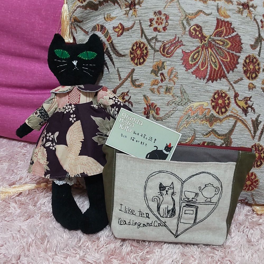 黒猫のぬいぐるみ（和柄のワンピースを着ている）と刺繍ポーチ（ハートの中に猫とティーセット、本。ハートの横にはI like tea reading and catと書かれている）
作家：granda nigra Kato