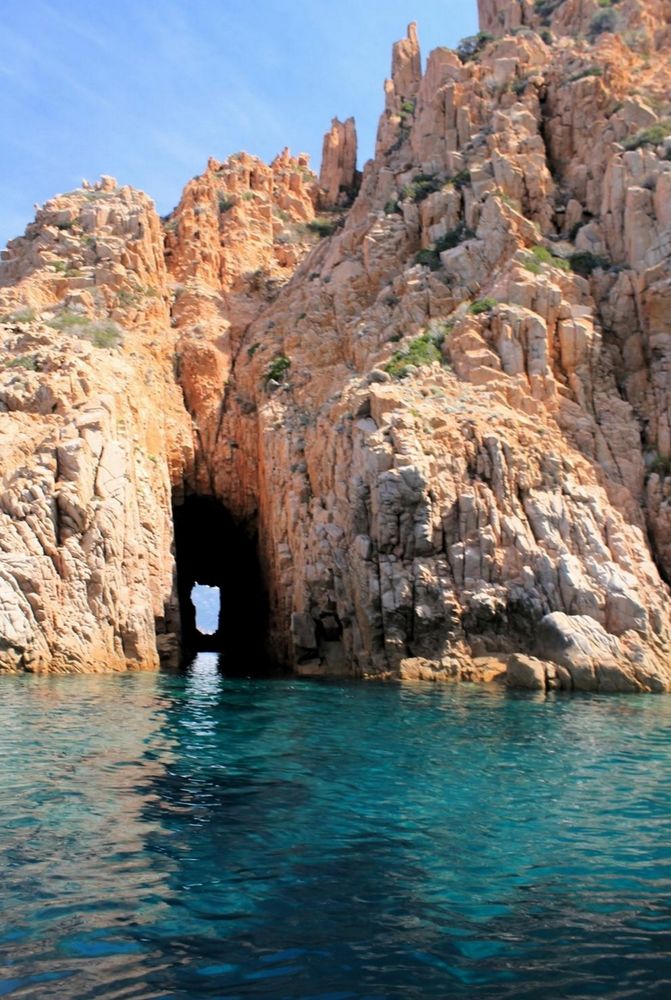 On a turquoise blue sea, orange-red rocks with a cave and an opening in the background (Piana-Corsica).
📸: arnaud audoin.