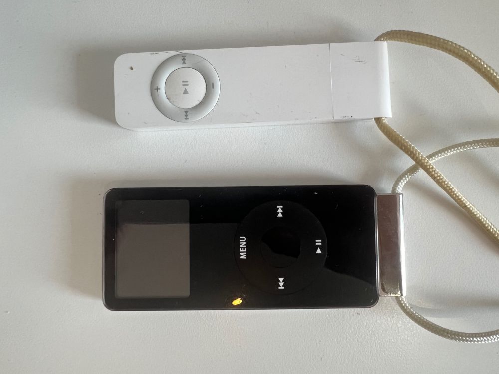 Original iPod shuffle and iPod nano, side by side, with their lanyards attached.
