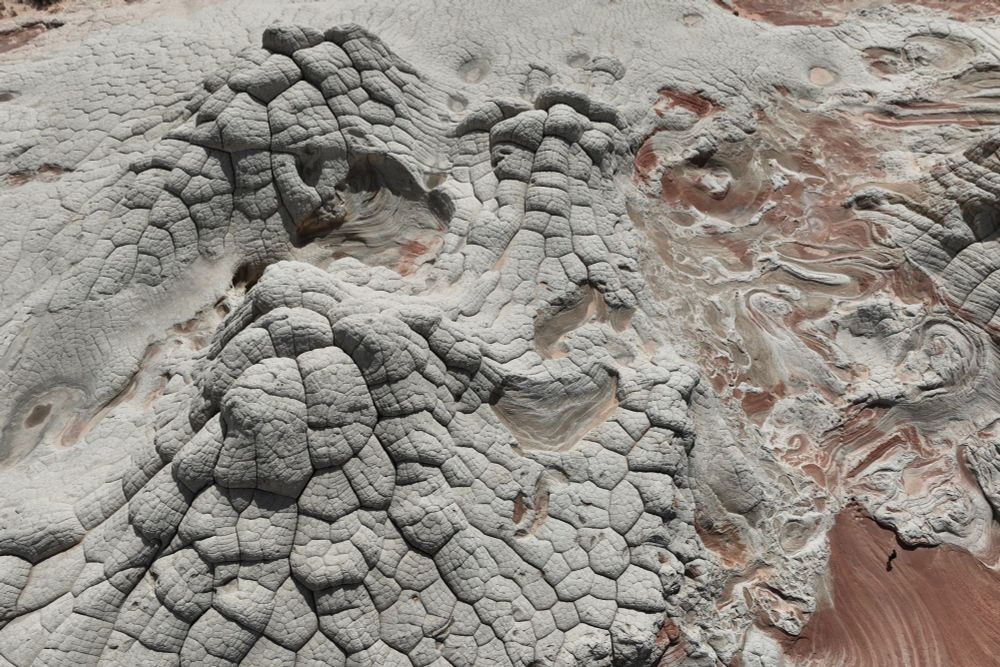 Two domes covered with polygonal patterns on the left; soft sediment deformation (a swirly pattern of layered red sandstone) on the right