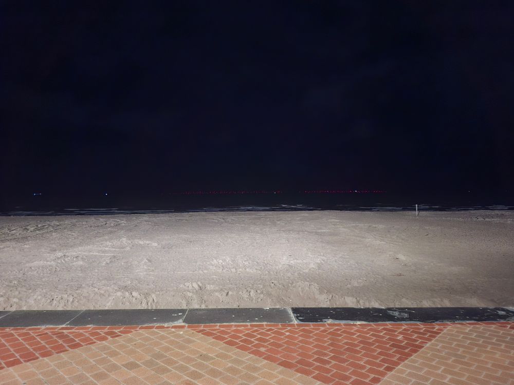 Strand von blankenberge beleuchtet mit leuchtenden windpark im Hintergrund