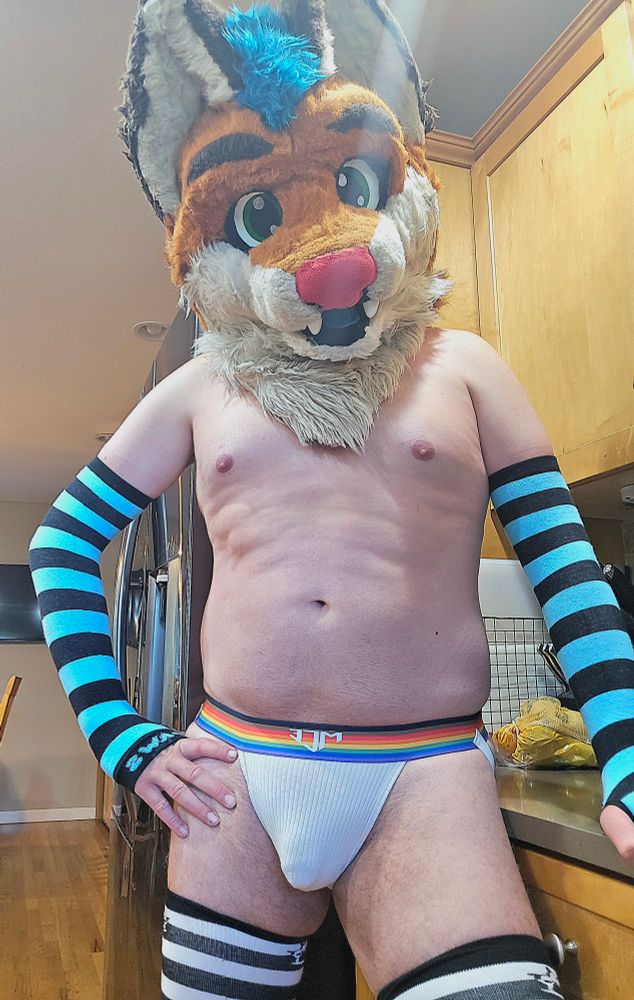 Me wearing a white jock with a rainbow band, teal arm warmers and black/white leg warmers