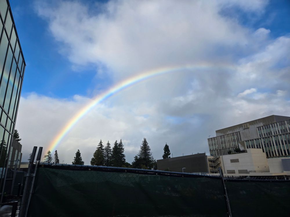 A rainbow and a cloudy sky over a construction zone