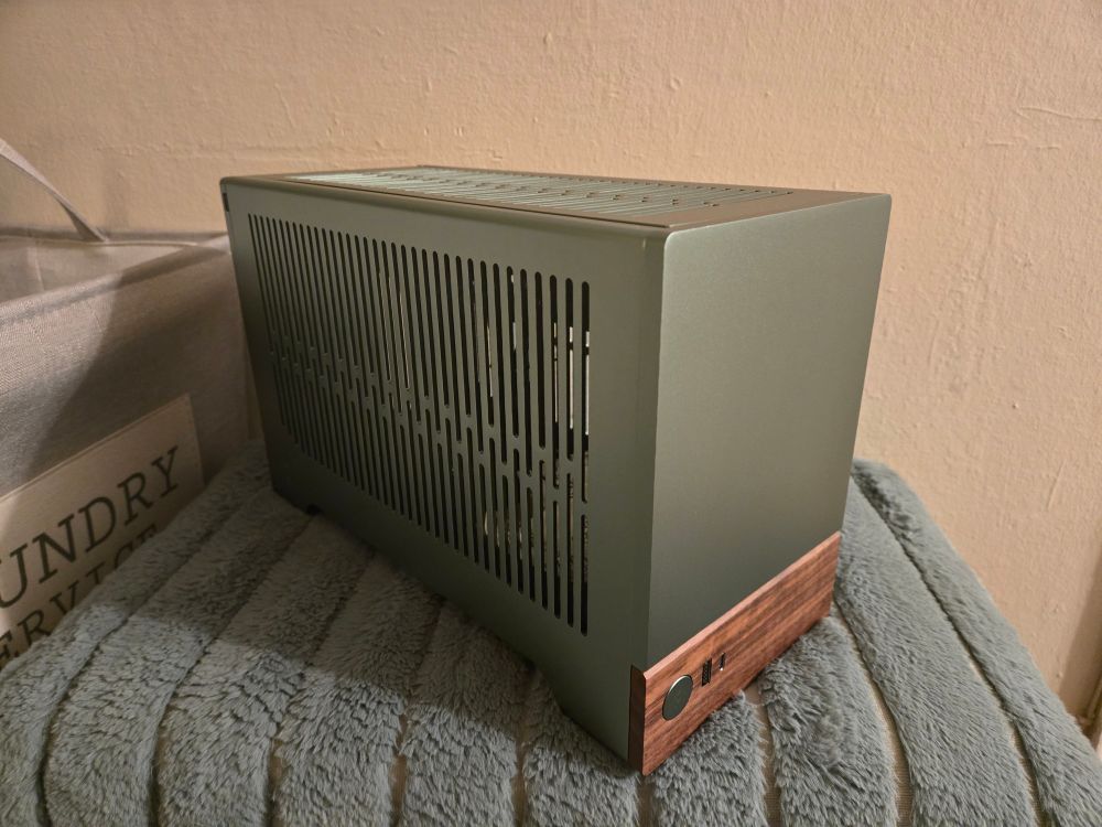 A fractal design terra computer case in green with a wooden panel on the front