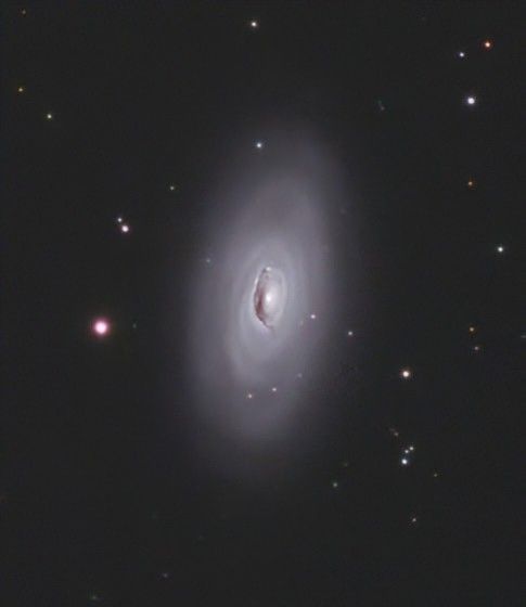 A mostly diffuse spiral galaxy with a dark core. 