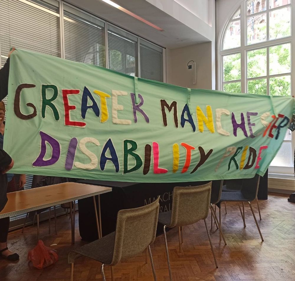 Fabric hand made banner saying in multicoloured letters -Greater Manchester Disability Pride