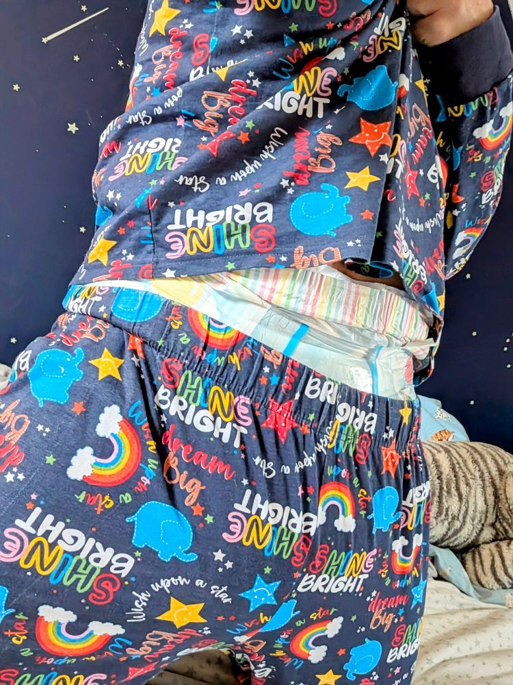 I am partially lifting my pajama top to reveal my overnight diaper waistband peeking out. 