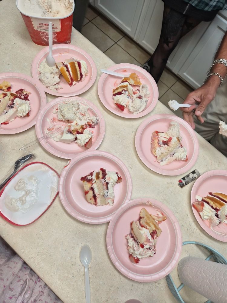 A countertop full of plates with slices of cake on them.