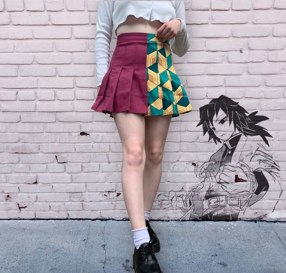 Model wearing a pleated skirt with a design inspired by Giyu from Demon Slayer, the design is split down the middle.
