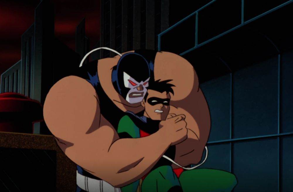 Robin (Dick Grayson) in his college years is grabbed and easily overpowered by Bane, whose enormous arms dwarf the Boy Wonder on Batman The Animated Series.