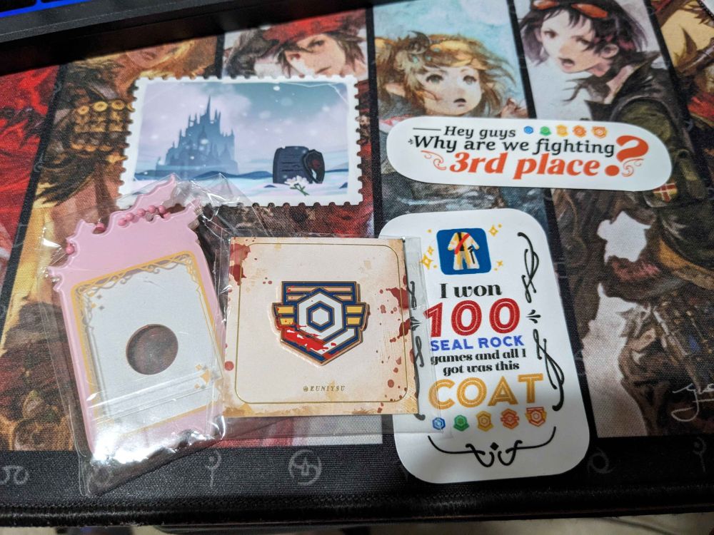 My goodies from SeaTeas which consists of an acrylic photo frame, an Ishgard sticker, Battle High V Pin, Sticker that says "I won 100 seal rock matches and all I got was this coat" and another sticker that says "Hey guys why are we fighting 3rd place?"