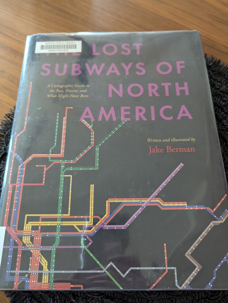 The cover of Lost Subways of North America. Lines of a subway system against a black background. A large number are vertical near the spine. There are many different colors and several stations with more than one line.