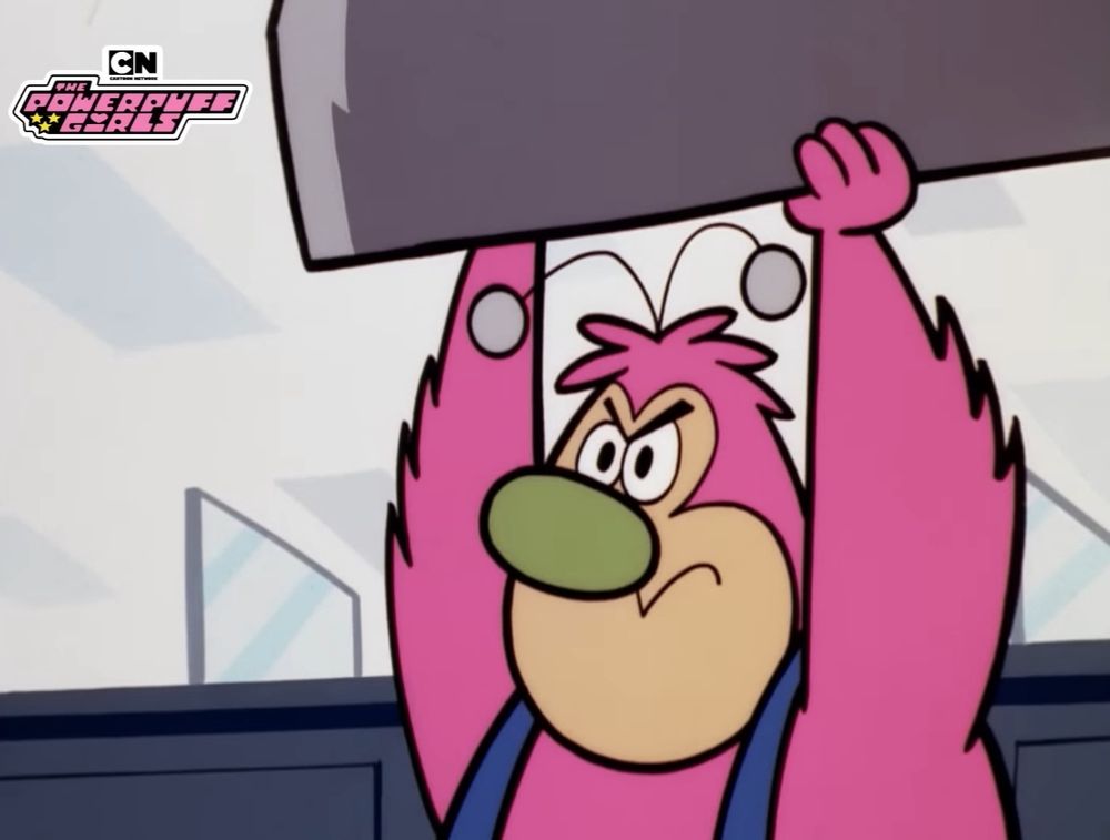 Screenshot from Powerpuff Girls, with a pink Fuzzy Lumpkins holding a bolder above his head.